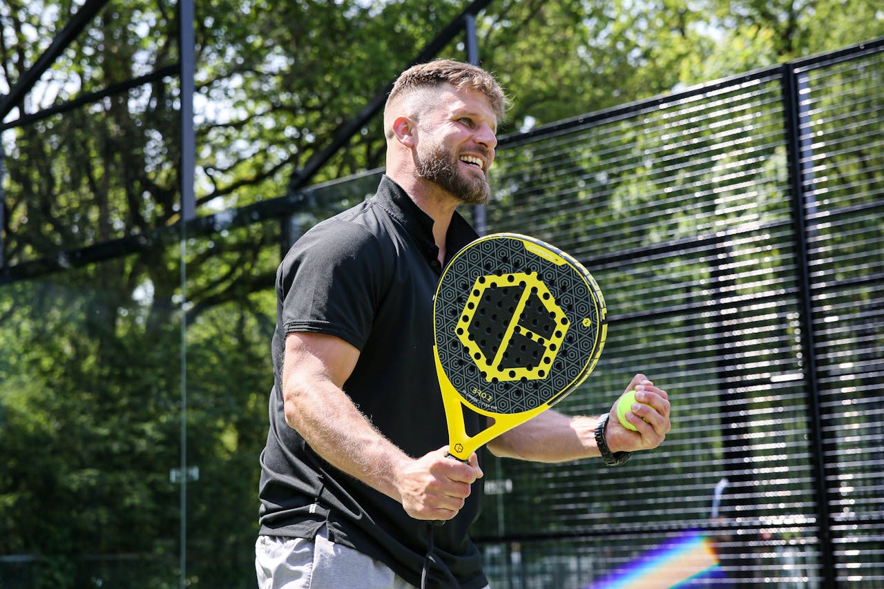 The Art of Drawing Readers In: Your attractive post title goes here Excited man playing tennis outdoors in Bussum, smiling and holding a racket.