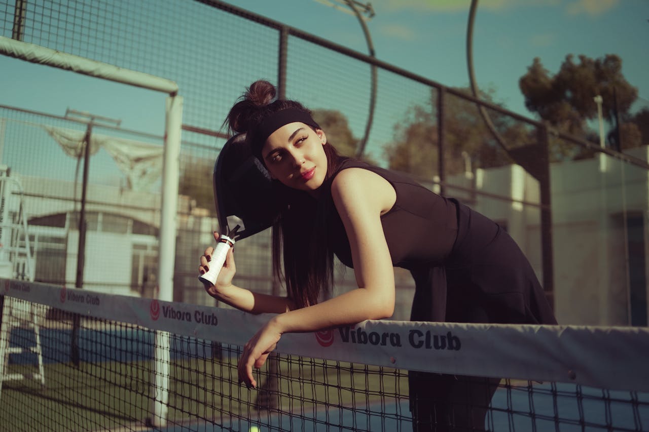 Mastering the First Impression: Your intriguing post title goes here A young woman leaning on a tennis net outdoors on a sunny day in Baghdad, Iraq.